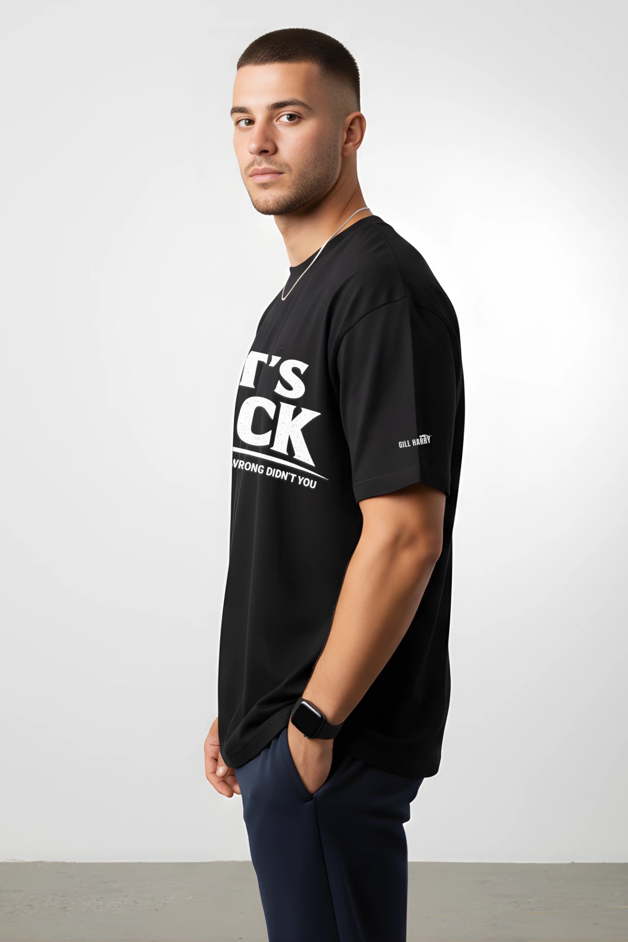 Side and back view of unisex oversized black tee by Gill Harry — clean back, drop-shoulder silhouette, ribbed hem, and minimal sleeve branding — premium terry-knit fit for modern street style