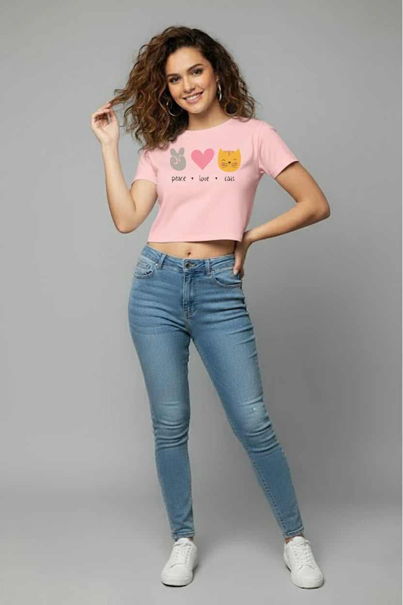 Woman wearing a pink t-shirt with cat designs and blue jeans on a gray background